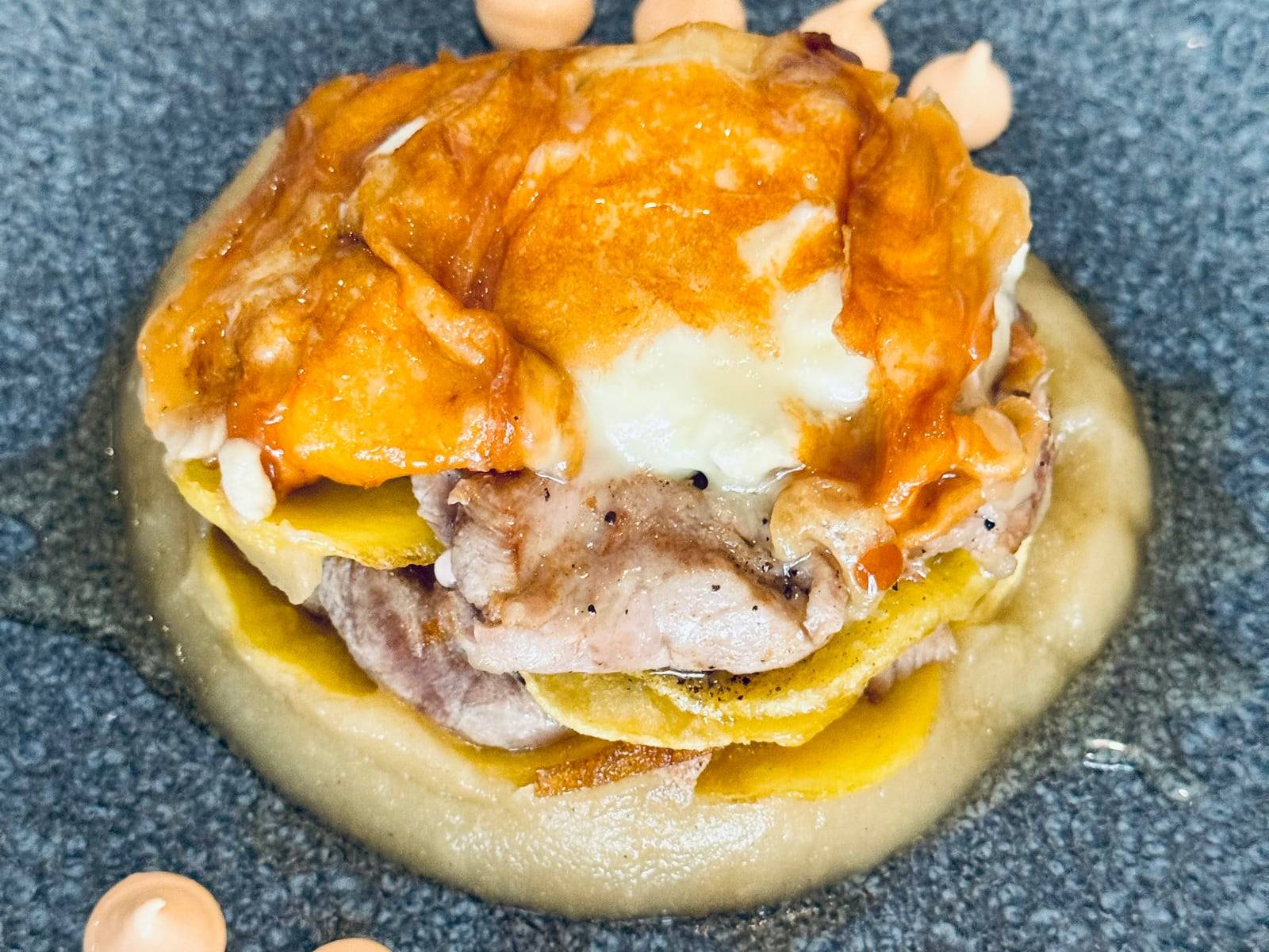 Timbal de patata confitada con compota de manzana, láminas de solomillo de cerdo y crujiente de queso de cabra, de La Josefita